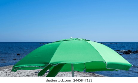 Green beach umbrella. Blue sky. Relaxing context. Summer holidays at the sea. General contest and location - Powered by Shutterstock