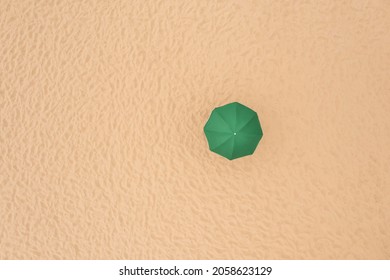 Green Beach Umbrella On Sandy Coast, Aerial View. Space For Text