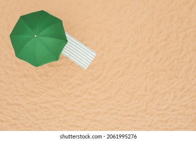 Green Beach Umbrella And Towel On Sandy Coast, Aerial View. Space For Text