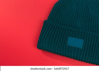 Green Beanie Hat On Red  Background 
