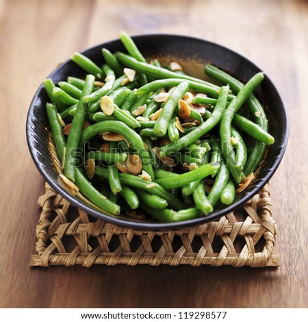 Green beans with almonds in wooden bowl