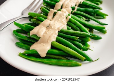 Green Beans with a Dijon-Tahini Sauce and Sesame Seeds: A platter of string beans topped with sauce and sesame seeds