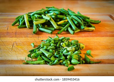Green beans split into two piles, end cuts and edibles