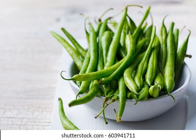 Green Beans In White Bowl On Cutting Board.