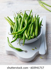 Green Beans In White Bowl On Cutting Board. Close Up.