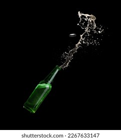 Green beer bottle opening with exploding and splashing on dark background