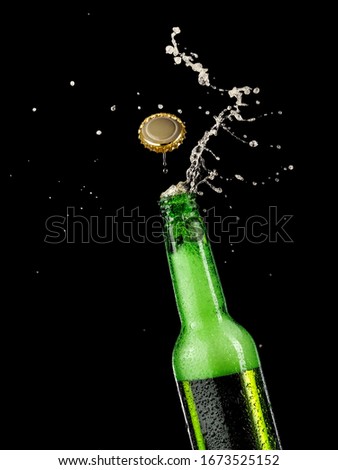 Green beer bottle opening with flying cap, close up