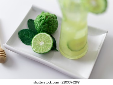 A Green Bergamot With Freshly Squeezed Bergamot Juice On White Tray