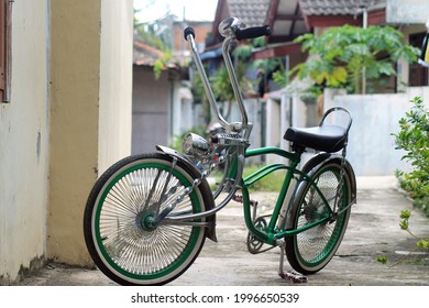 Green Bicycle On A Street. This Bike Is Also Known As The Lowrider.