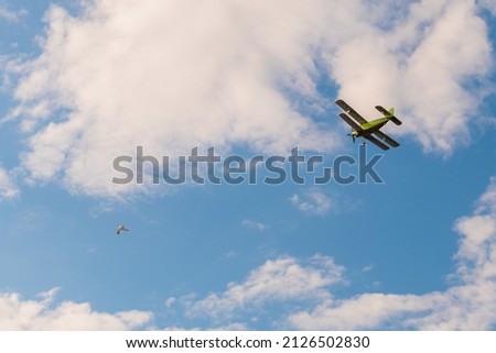 Green biplane, retro airplane flying in blue sky and doing stunts at Air Show. Performance, extreme, aerobatic, sport and aircraft concept