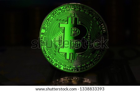 Green Bitcoin BTC coin is surrounded by a gloomy background