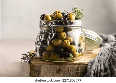 Green and black olives mix, in a glass jar. Delicious, marinated olives.  - Powered by Shutterstock