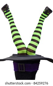 Green and black striped witch's legs coming out of a hat. White background.