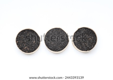 Green and black tea leaves in cardboard round boxes on whitebackground
