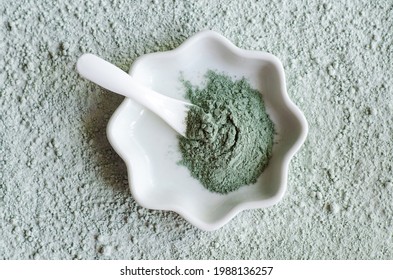 Green (blue) bentonite clay powder in a bowl. Clay texture close up. Diy face mask and body wrap recipe. Natural beauty treatment and spa. Top view, copy space