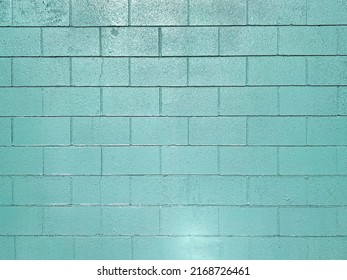 a green blue closeup solid block brick wall cement cinder blocks exterior building alley turquoise shadow
