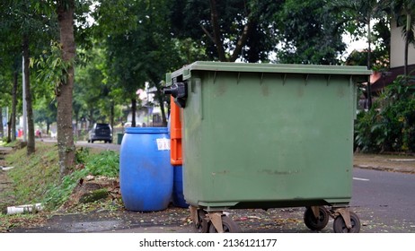 Green And Blue Dumpster In The Sidewalk 