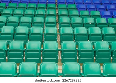 Green and blue plastic spectator stadium seats. Nobody, empty rows.