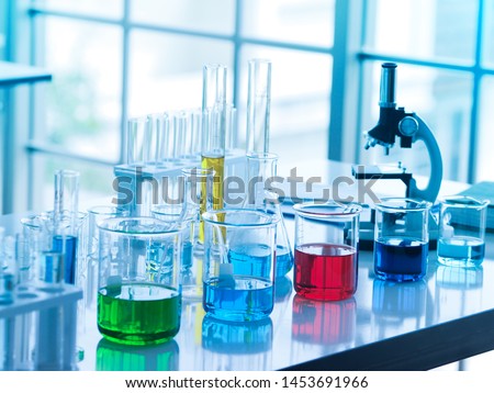 green, blue, red , and dark blue color liquid in glass beaker and yellow one in tube at the laboratory for researchers to do their work.