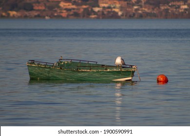 Green Boat And Red Buoyancy Floating In The Lake