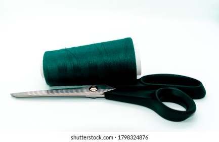 Green bobbin thread and black scissors isolated on white background. Close up of a spool of green sewing thread. Thread is a type of yarn but similarly used for sewing.  - Shutterstock ID 1798324876