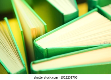 Green books on a yellow background - open pages 