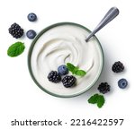 Green bowl of greek yogurt and fresh berries isolated on white background, top view