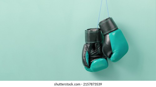 Green Boxing Gloves Weigh On A Green Wall. Template Copy Space For Text. Mock-up.