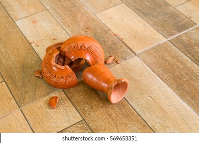 Green Broken Vase On A Wooden Floor