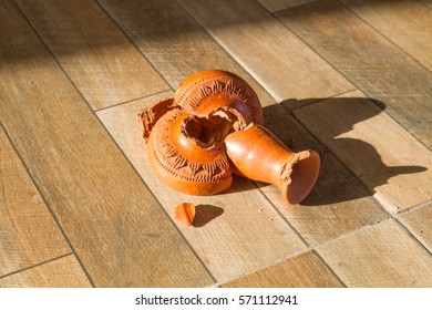 Green Broken Vase On A Wooden Floor