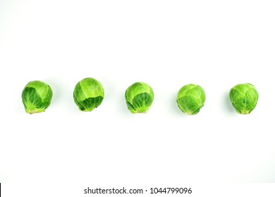 Green brussel sprouts isolated on white purple background and blue background, single, sorted, align, arranged in a triangle, with modern and fashion style