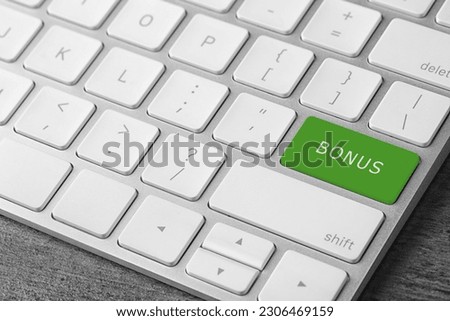 Green button with word Bonus on computer keyboard, closeup
