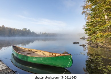 Green Canoe Tied To Dock On A Lake In Autumn - Ontario, Canada