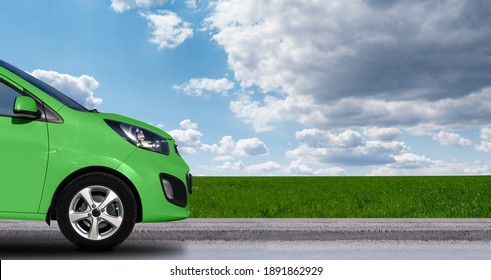 Green Car On The Background Of Blue Sky And Field. Copy Space