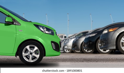 Green Car On A Background Of Cars In A Rows.