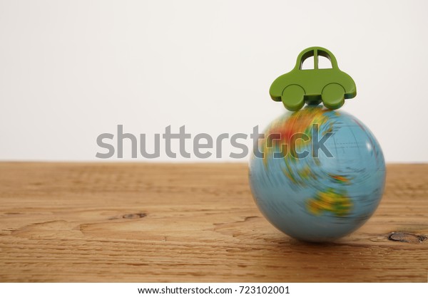 green Car toy figure on\
globe map. Miniature car toy.  car on the globe isolated on  white\
background