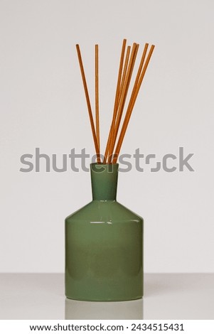 Green ceramic diffuser with brown reed sticks