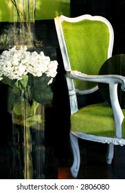 green chair and vase of flowers displayed in a store window