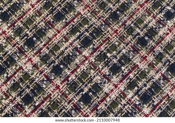 Green checkered fabric with colored threads. Scottish wool. Fabric for a plaid coat and suit. Close-up. Background