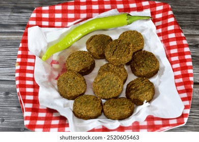 Green chili pepper and traditional Egyptian fried falafel balls served in a plate, green burger, made of ground chickpeas and broad beans, deep fried balls or patty-shaped fritter - Powered by Shutterstock