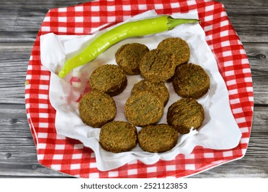 Green chili pepper and traditional Egyptian fried falafel balls served in a plate, green burger, made of ground chickpeas and broad beans, deep fried balls or patty-shaped fritter - Powered by Shutterstock