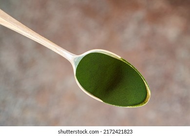 Green Chlorella Algae Powder On A Spoon, Top View