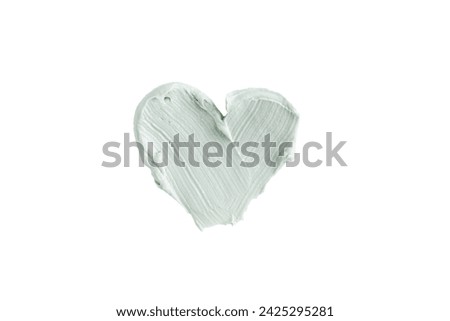 Green clay mask or correcting concealer smear smudge in the shape of a heart isolated on white background. Cream texture. Facial mask, skincare beauty product swatch closeup. SPA background