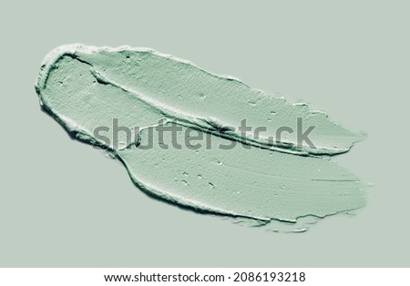 Green clay mask sample on green background