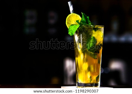 Green cocktail with mint and lemon on the bar. Cocktail served