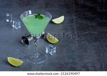 Green cocktail witn gin and mint in the martini glass, selective focus. Copy space for your advertising content