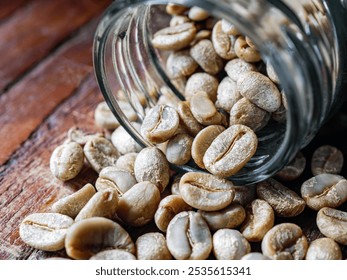 Green coffee beans poured out of a glass jar, Close-up of green raw coffee bean, unroasted coffee bean - Powered by Shutterstock