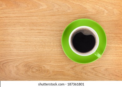 Green Coffee Cup On Office Wooden Table. View From Above With Copy Space