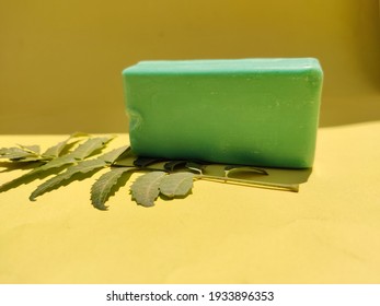 Green Color Soap Bar With Neem Leaves Isolated On Yellow Background