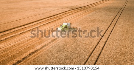 Similar – Image, Stock Photo Mähdräscher harvests a grain field in the evening light from the air